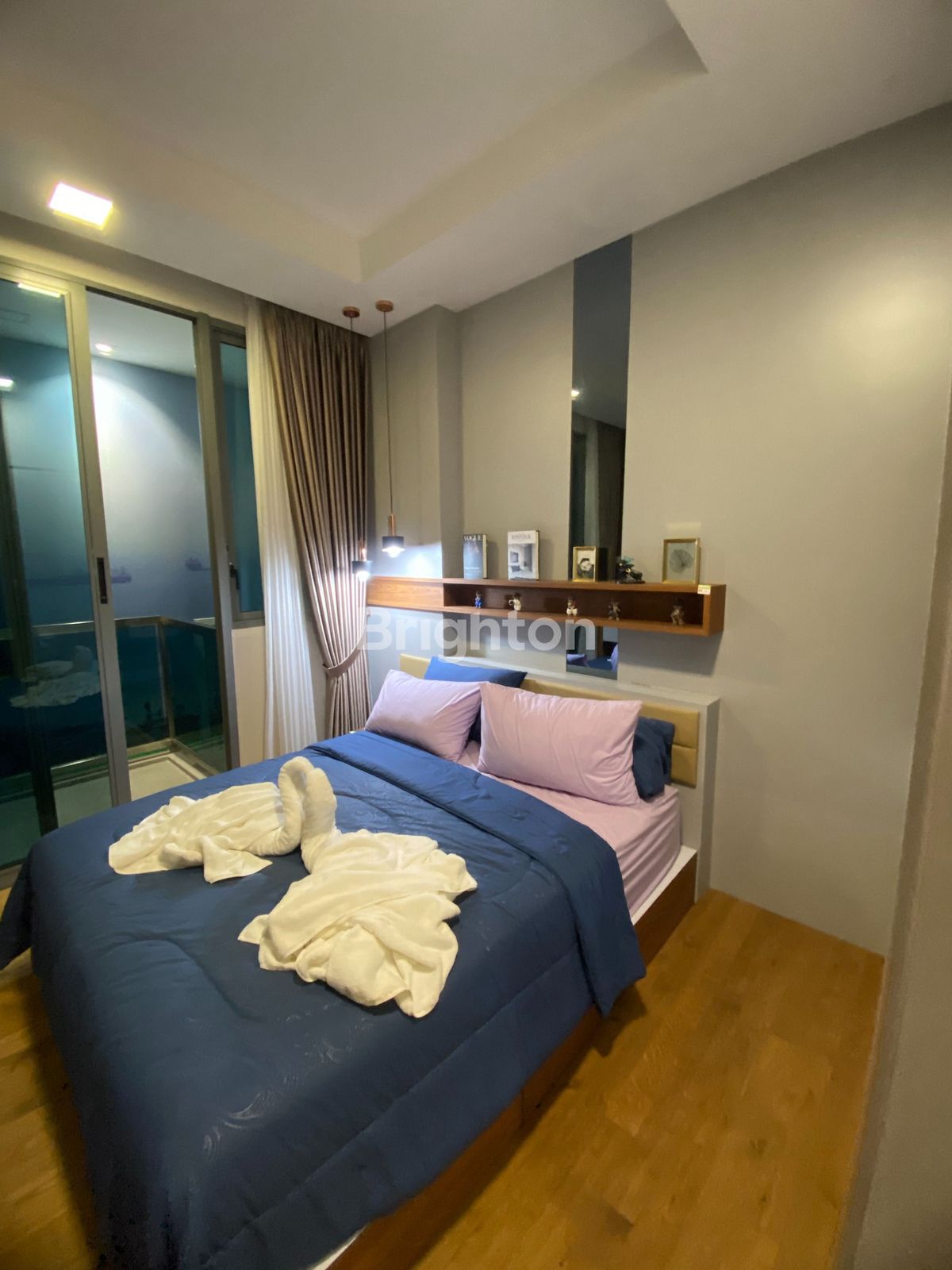 Tempat tidur dan jendela apartemen studio Nagoya Hill Batam