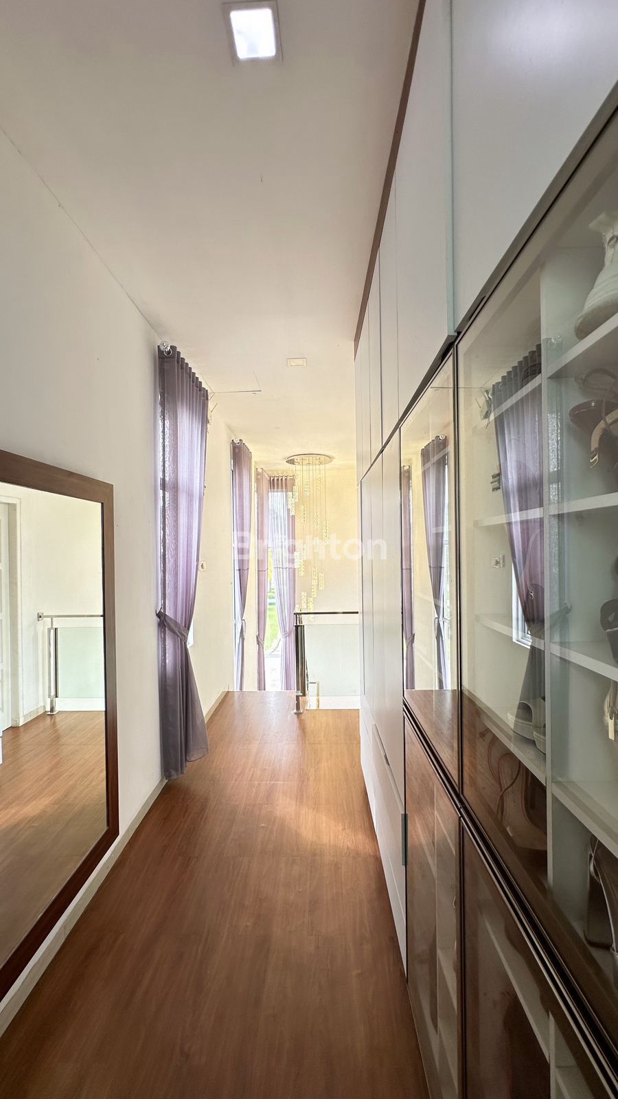 Lorong lantai atas dengan lemari kaca di rumah Taman Golf Sukajadi Batam