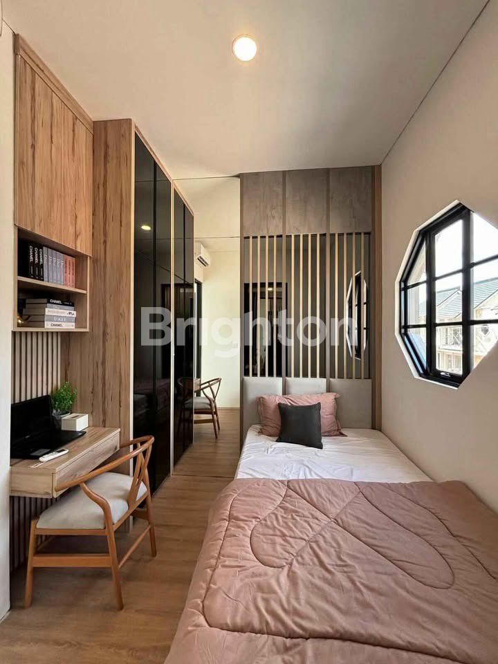 Kamar tidur dengan jendela bulat di rumah Osaka Hills CitraLand Megah Batam